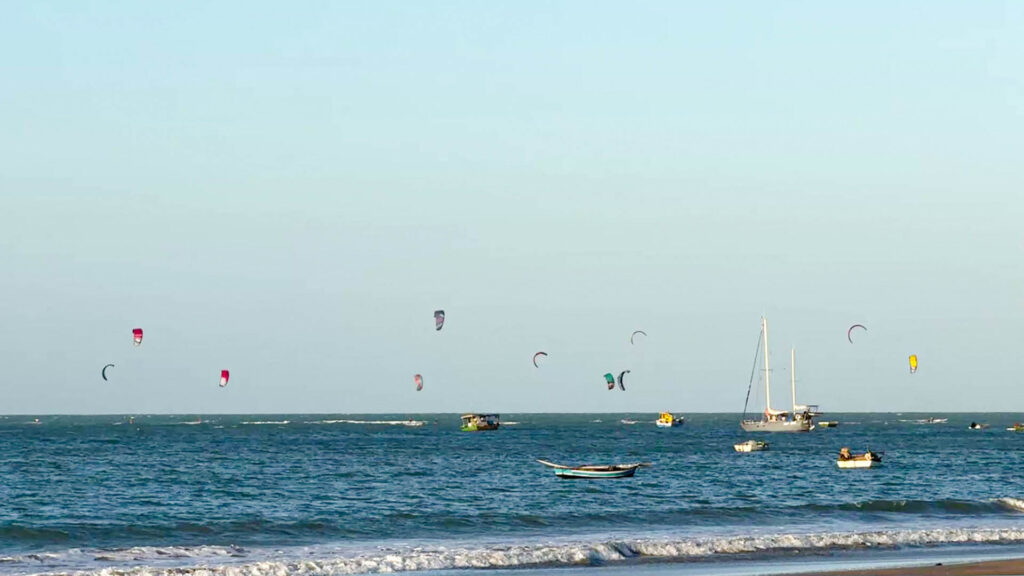 Pessoas praticando kitesurf sobre o mar em Icaraizinho de Amontada