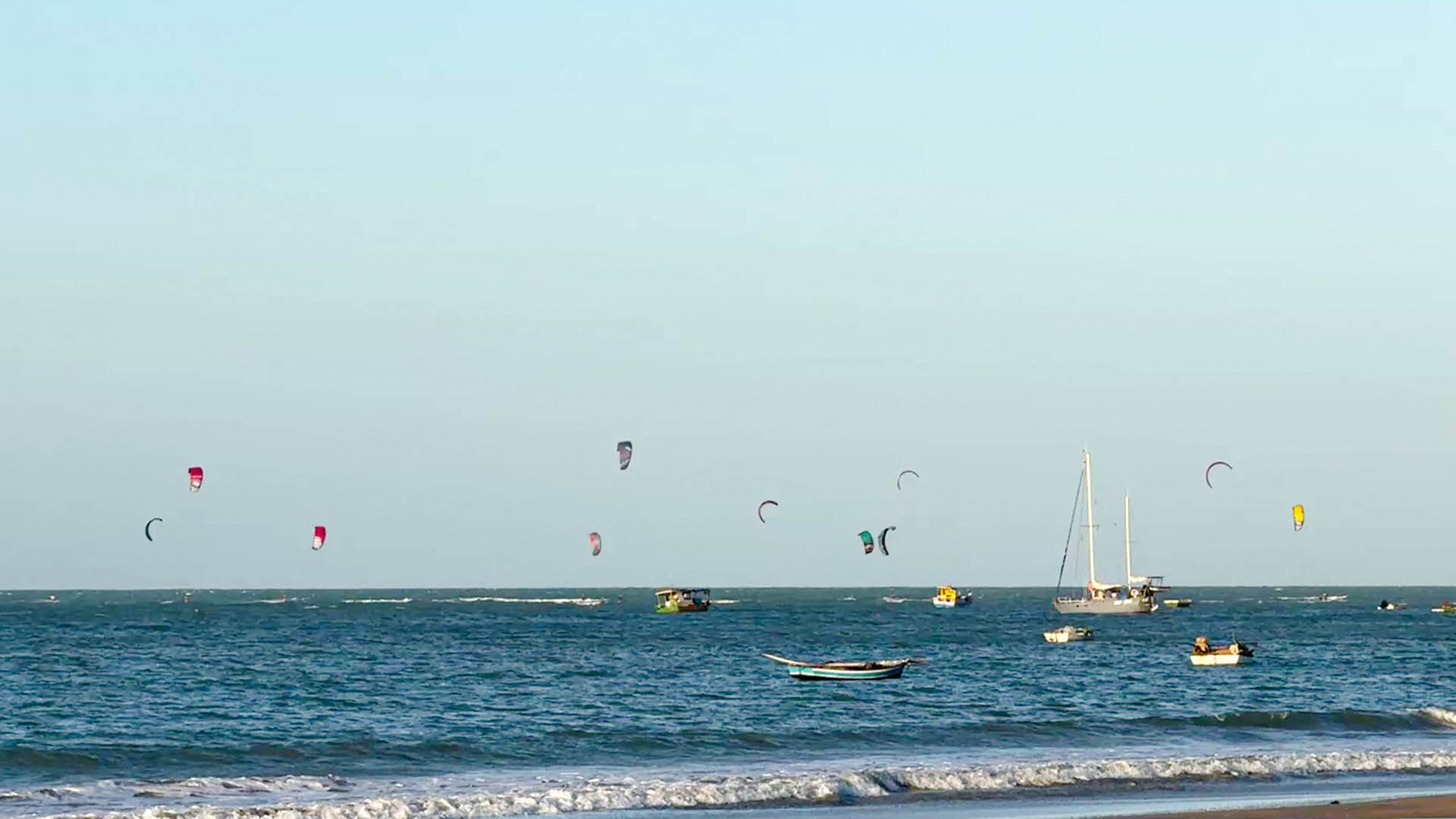 Pessoas praticando kitesurf sobre o mar em Icaraizinho de Amontada